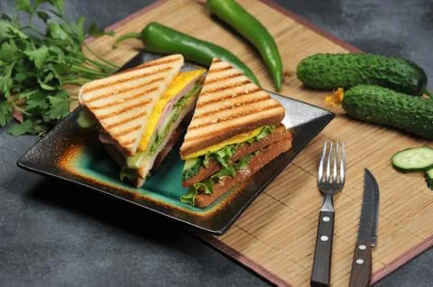 Triangular shaped sandwiches with ham and omelet on a plate Stock Photos