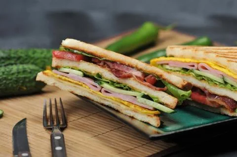 Triangular shaped sandwiches with ham and omelet on a plate Stock Photos