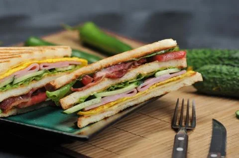 Triangular shaped sandwiches with ham and omelet on a plate Stock Photos