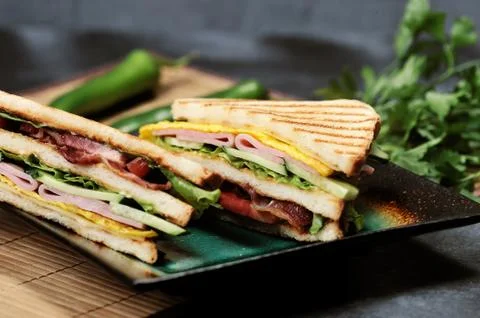 Triangular shaped sandwiches with ham and omelet on a plate Stock Photos