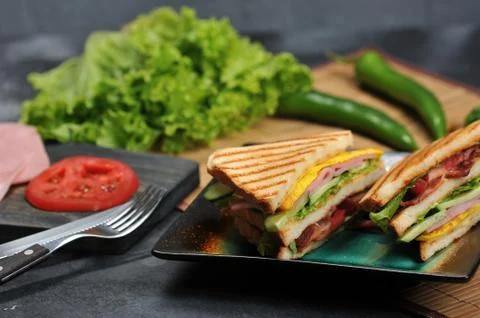 Triangular shaped sandwiches with ham and omelet on a plate Stock Photos