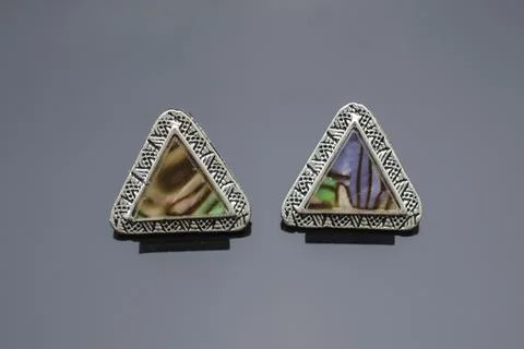 Triangular silver earrings with marble isolated on black 写真素材
