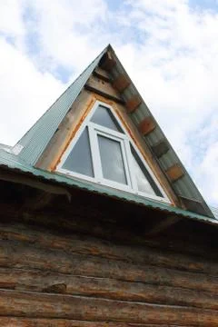 Triangular skylight of an attic of a village log house under construction aga Foto stock