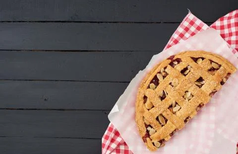 Triangular slice of baked cherry pie on a white paper Foto stock