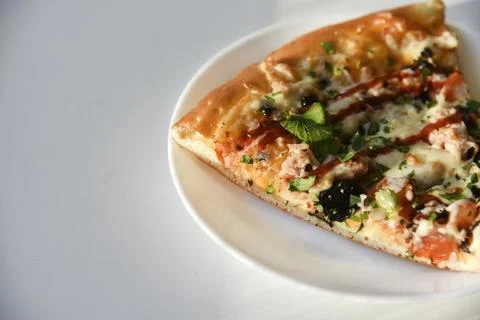 Triangular slice of pizza on a white plate Foto stock
