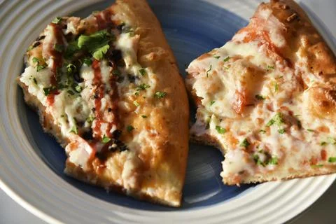 Triangular slice of pizza on a white plate Foto stock