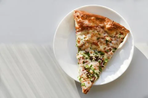 Triangular slice of pizza on a white plate Foto stock