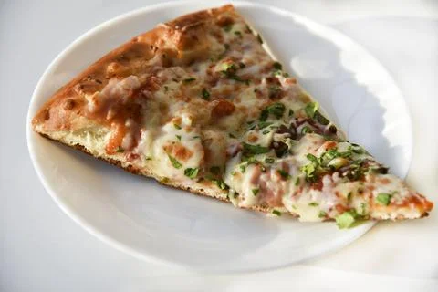 Triangular slice of pizza on a white plate Foto stock