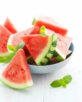 Triangular slices of fresh watermelon on white wooden background Stock Photos