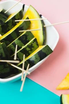 Triangular slices of ice cream on a stick of ripe yellow watermelon in a plat Stockfoto's