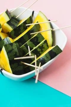 Triangular slices of ice cream on a stick of ripe yellow watermelon in a plat Stock Photos