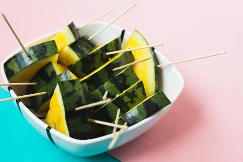 Triangular slices of ice cream on a stick of ripe yellow watermelon in a plat Stockfoto's