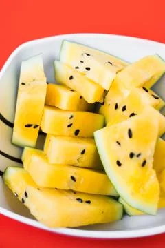 Triangular slices of ice cream on a stick of ripe yellow watermelon in a plat Fotos de archivo