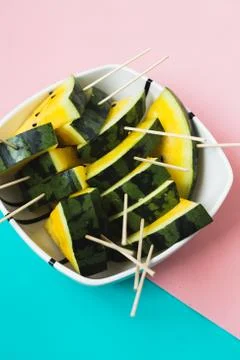 Triangular slices of ice cream on a stick of ripe yellow watermelon in a plat 写真素材