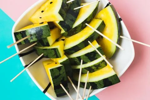 Triangular slices of ice cream on a stick of ripe yellow watermelon in a plat 写真素材