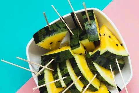 Triangular slices of ice cream on a stick of ripe yellow watermelon in a plat 写真素材