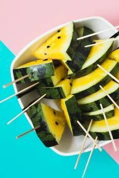 Triangular slices of ice cream on a stick of ripe yellow watermelon in a plat 写真素材