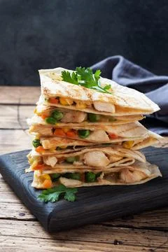 Triangular slices of a Mexican quesadilla with the sauce. The traditional d.. Foto stock
