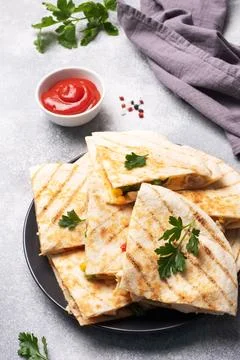 Triangular slices of a Mexican quesadilla with the sauce. The traditional d.. Foto stock