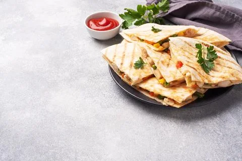 Triangular slices of a Mexican quesadilla with the sauce. The traditional d.. 스톡 사진