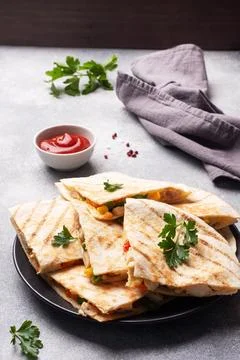Triangular slices of a Mexican quesadilla with the sauce. The traditional d.. Stock-Fotos