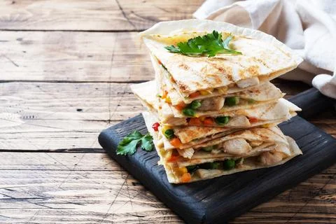 Triangular slices of a Mexican quesadilla with the sauce. The traditional d.. Foto stock