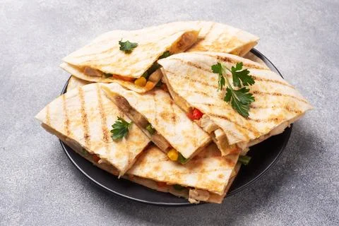 Triangular slices of a Mexican quesadilla with the sauce. The traditional d.. Foto stock
