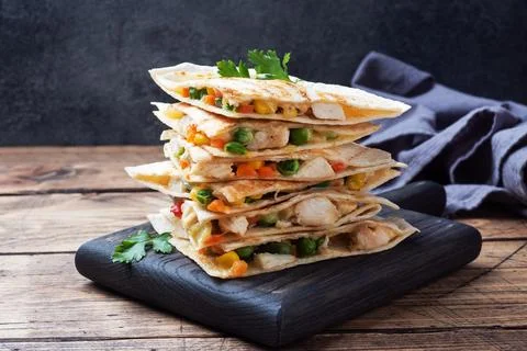 Triangular slices of a Mexican quesadilla with the sauce. The traditional d.. Stock Photos