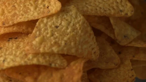 Triangular tortilla chips rotating on slate, nachos, salty snack flat lay Stock Footage 327579699