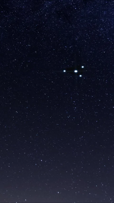 A triangular UFO flies over the ocean on a starry night. 3d render Stock Footage 295810933