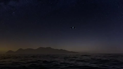A triangular UFO flies over the ocean on a starry night. 3d render Stock Footage 295810938