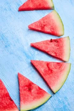 Triangular watermelon slices on blue background. Close up top view, flat lay. Stock Photos