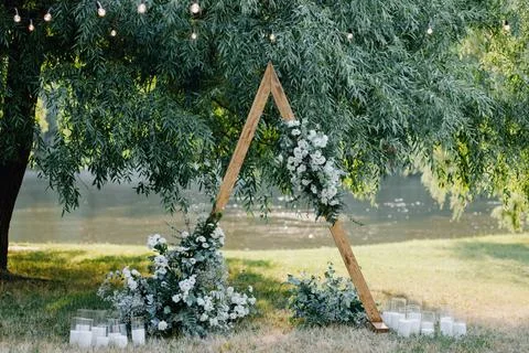 Triangular wedding arch with white flowers Foto stock