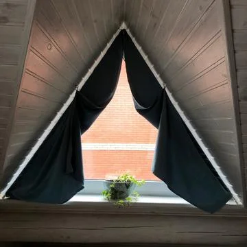Triangular window with a flowerpot on a white wood background Stock Photos