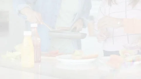 Triangular wipe revealing countertop, two cooks using pan and spatula to plate Stock Footage 333397186