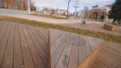 Triangular wooden bench with burnt pattern in city park Stock Footage 194965239