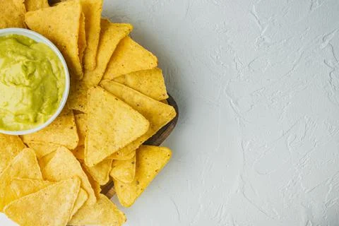 Triangular yellow corn tortilla chip with sauce, on white background, top vie 写真素材