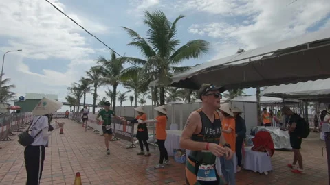 Triathlete heading out of the transition technical area to the run course at  Stock Footage 156674440