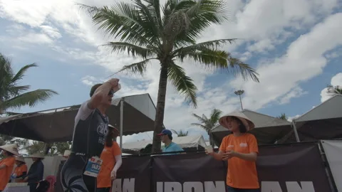 Triathlete heading out of the transition technical area to the run course at  Stock Footage 156674448