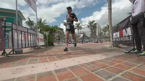 Triathlete heading out of the transition technical area to the run course at  Stock Footage 156674475
