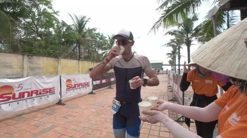 Triathlete heading out of the transition technical area to the run course at  Stock Footage 156674506