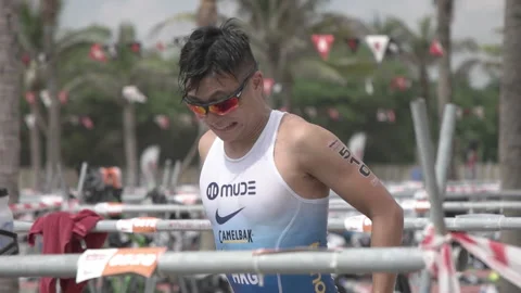 Triathlete heading out of the transition technical area to the run course at  Stock Footage 156674686
