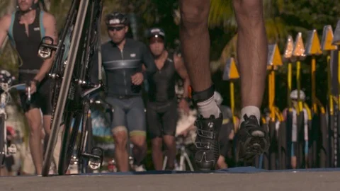 Triathletes Running with Bikes in Slow Motion Stock Footage 82879770