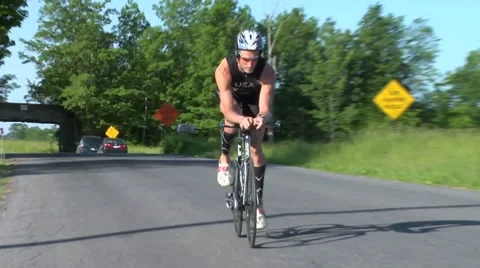 Triathlon biking by older male biker in aero position Stock Footage