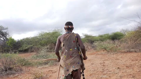 Tribe man walking through the bush going to hunt animals with bow and Stock Footage 169833763