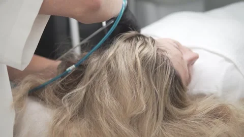 A trichologist doctor does a procedure to increase hair growth on the head for a Stock Footage 311047231