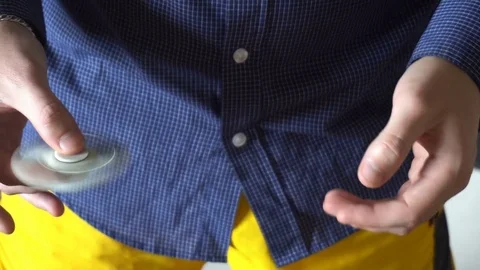 The trick with the hand spinner on a black background,the young man throws the Stock Footage 76783313