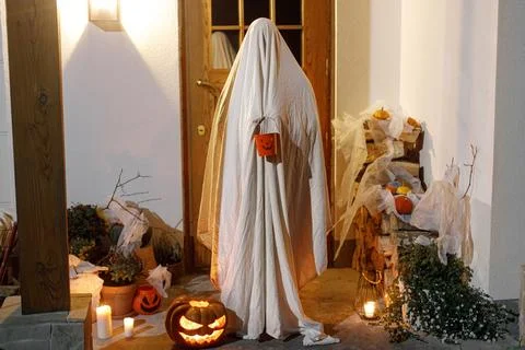 Trick or treating! Spooky ghost holding halloween candy bucket on backgroun.. Stock Photos