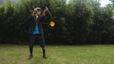 Trick tentative using a diabolo around the elbows by a cool man in ecuador Stock-Footage 113937758