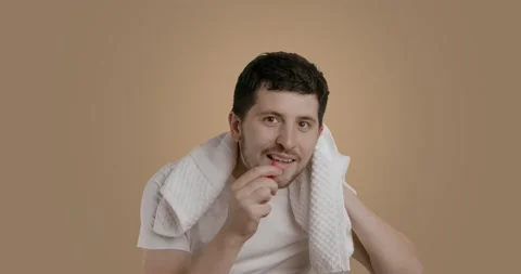 Tricky man cleaning his teeth with a small interdental brush. A young man wiping Stock Footage 222005339